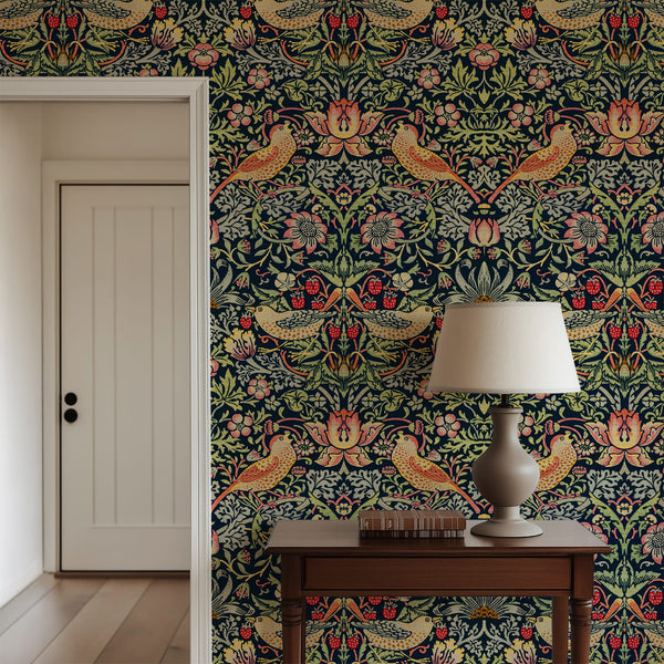 William Morris Strawberry Thief indigo wallpaper behind a wood console with a lamp
