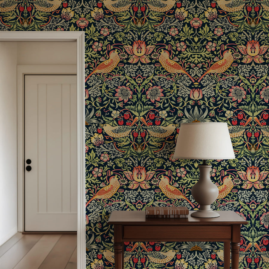 William Morris Strawberry Thief indigo wallpaper behind a wood console with a lamp